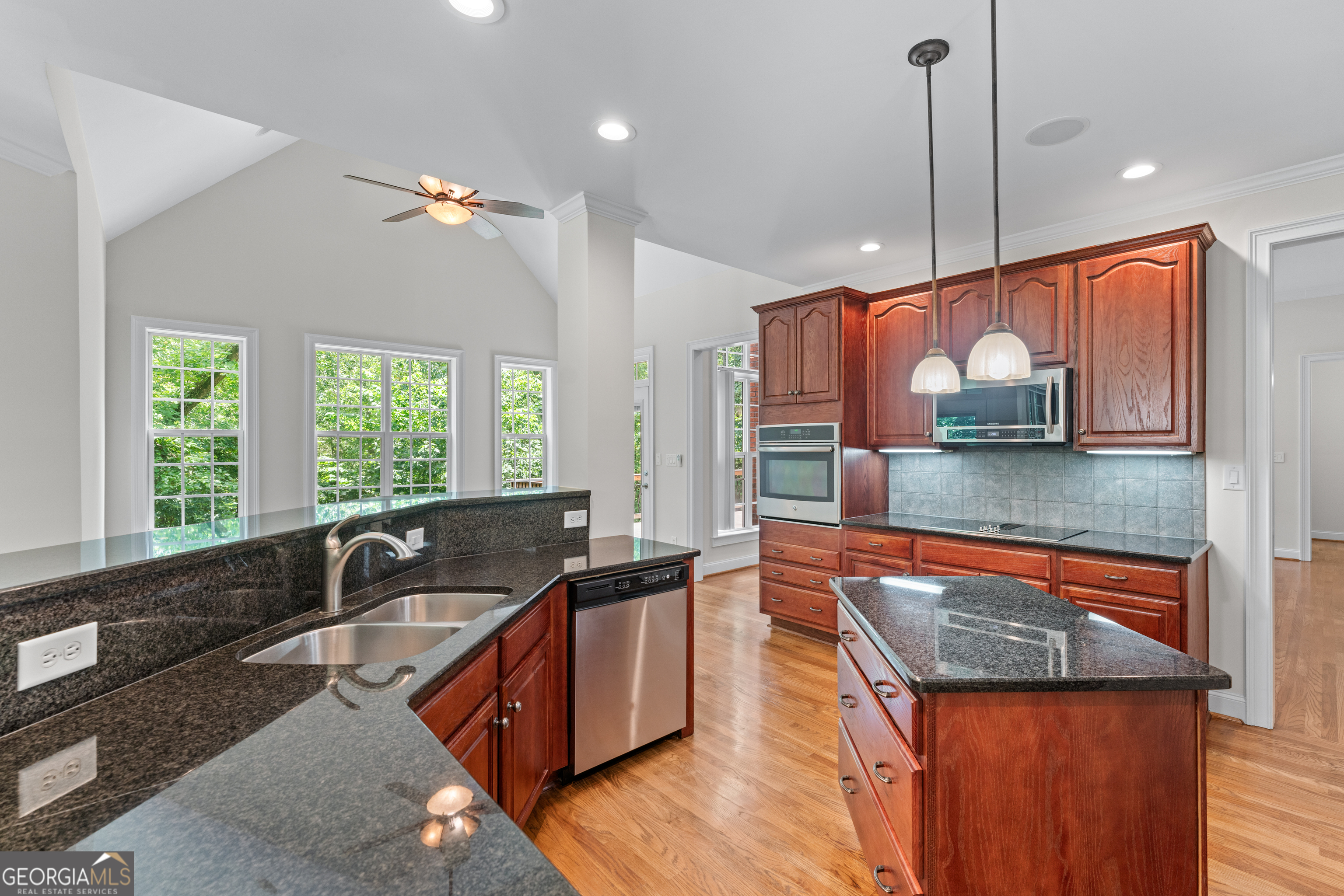 6020 Cochran Mill Road Chattahoochee Hills, GA 30213 - Photo 6 of 44 a kitchen with stainless steel appliances granite countertop a sink a stove and a wooden floor