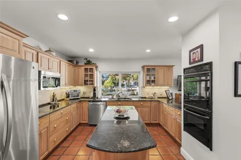 a kitchen with a sink a counter top space stainless steel appliances and cabinets