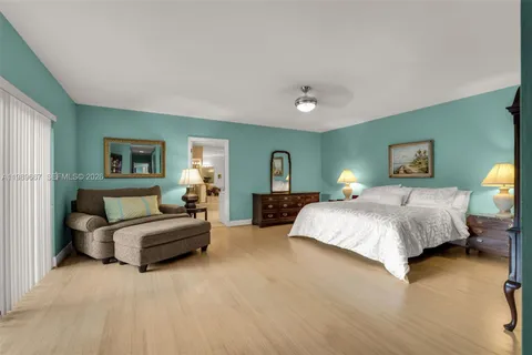 a spacious bedroom with a bed couch and window