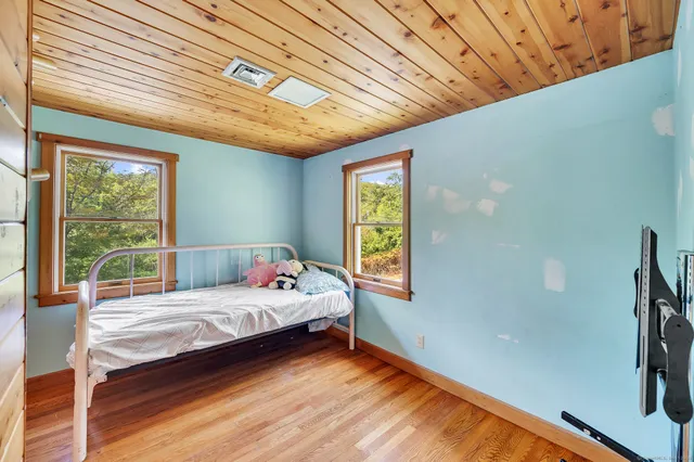 a bedroom with a bed and wooden floor