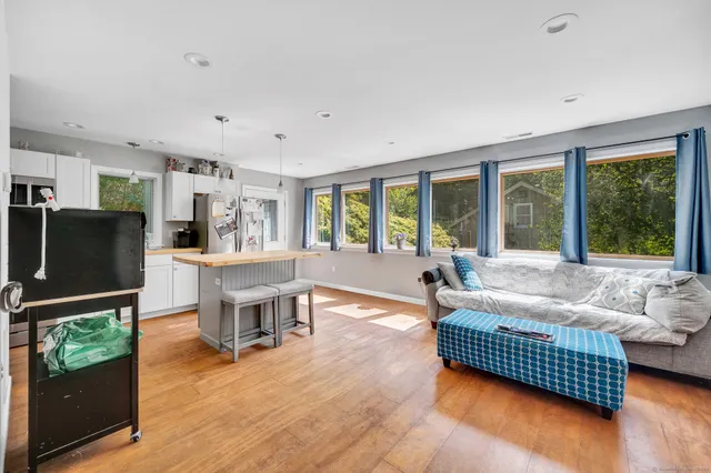 a living room with furniture and a flat screen tv with wooden floor