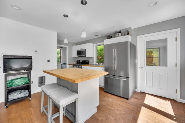 a kitchen with stainless steel appliances granite countertop a refrigerator a stove top oven a sink and dishwasher