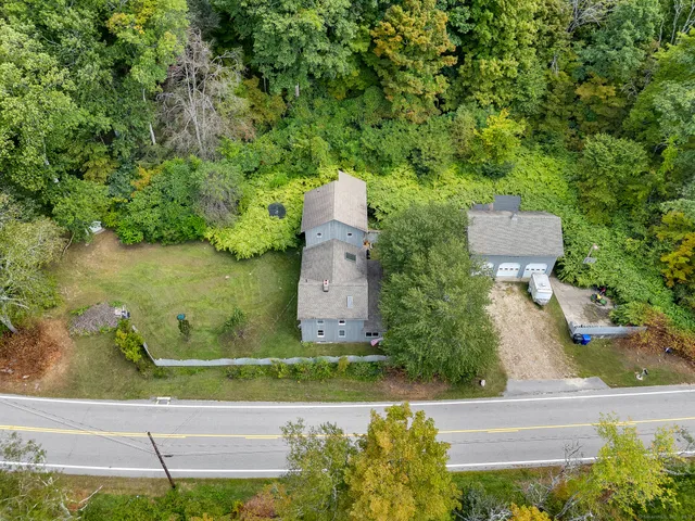 an aerial view of a house with a yard and lake view