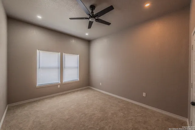 an empty room with a window and a fan