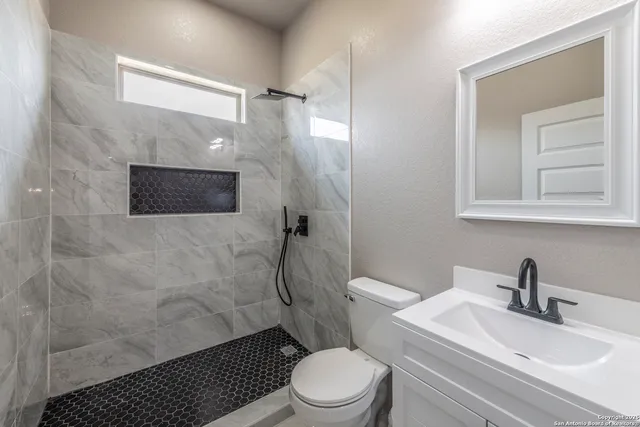 a bathroom with a sink toilet and shower