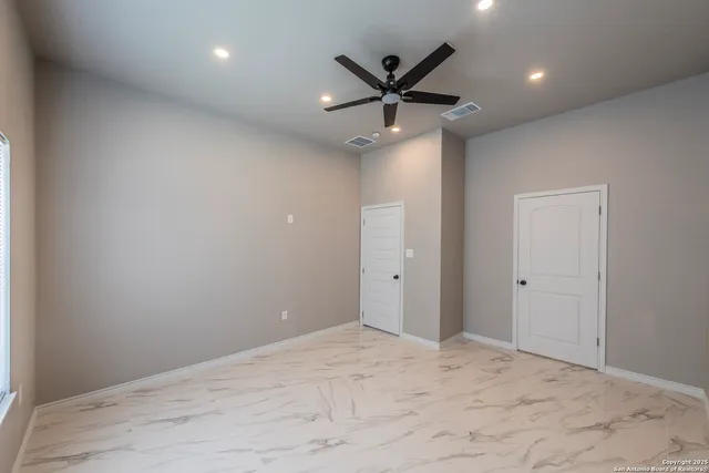 a view of a big room with wooden floor and windows
