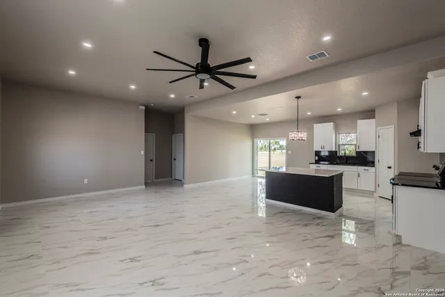 a view of kitchen with kitchen island stainless steel appliances sink cabinets and window
