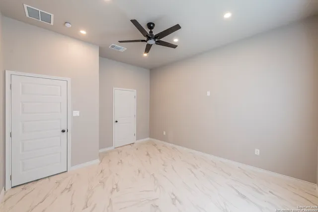 an empty room with closet and ceiling fan