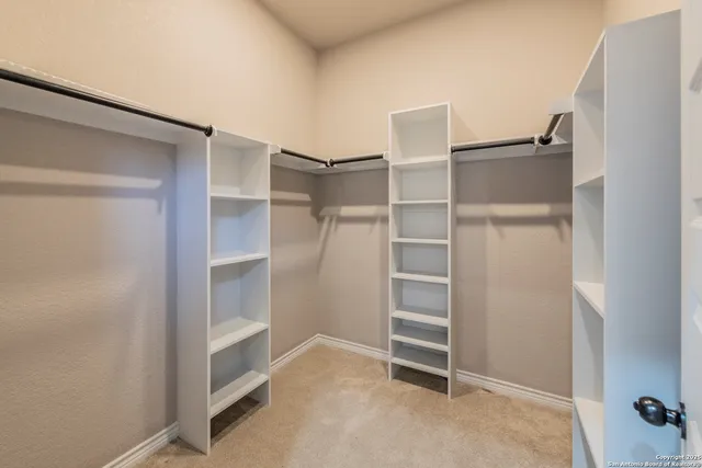 a view of walk in closet with empty racks