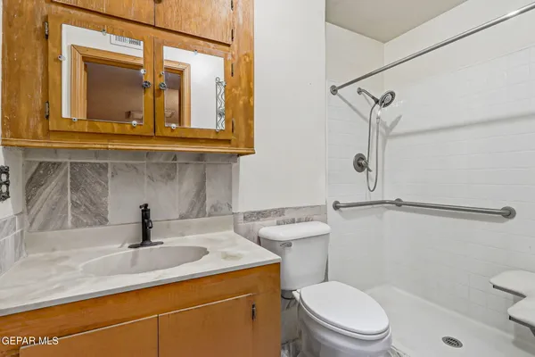 a bathroom with a sink a toilet and shower