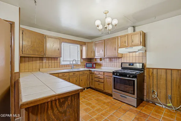 a kitchen with stainless steel appliances granite countertop a stove a sink dishwasher and a refrigerator