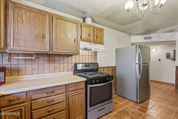 a kitchen with stainless steel appliances granite countertop a refrigerator stove and sink