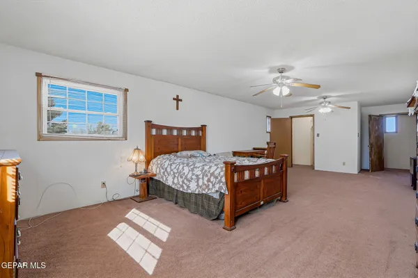 a bedroom with a bed chandelier and a window