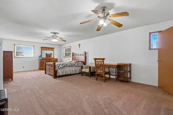 a bed room with furniture and a ceiling fan