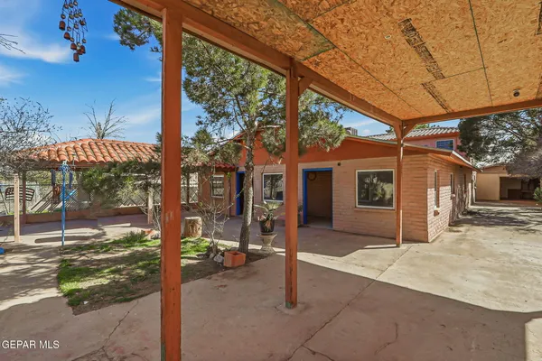 a porch with a table and chairs under an umbrella
