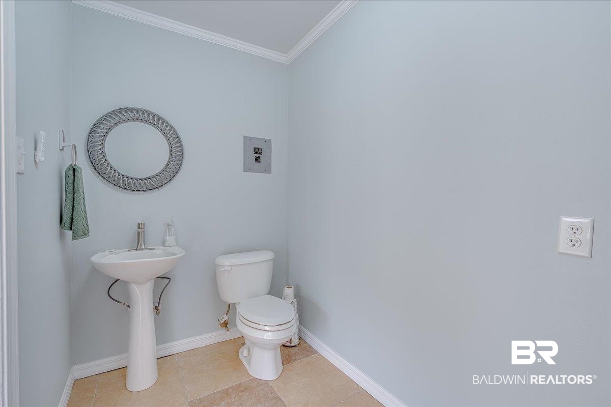 440 Dykes Road Mobile, AL 36608 - Photo 28 of 49 Bathroom featuring baseboards, a sink, tile patterned flooring, crown molding, and toilet