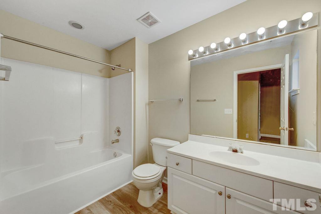 4104 Standing Rock Way Raleigh, NC 27604 - Photo 15 of 16 a bathroom with a toilet a sink and a large mirror