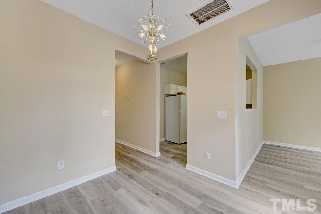 4104 Standing Rock Way Raleigh, NC 27604 - Photo 5 of 16 an empty room with wooden floor and a ceiling fan