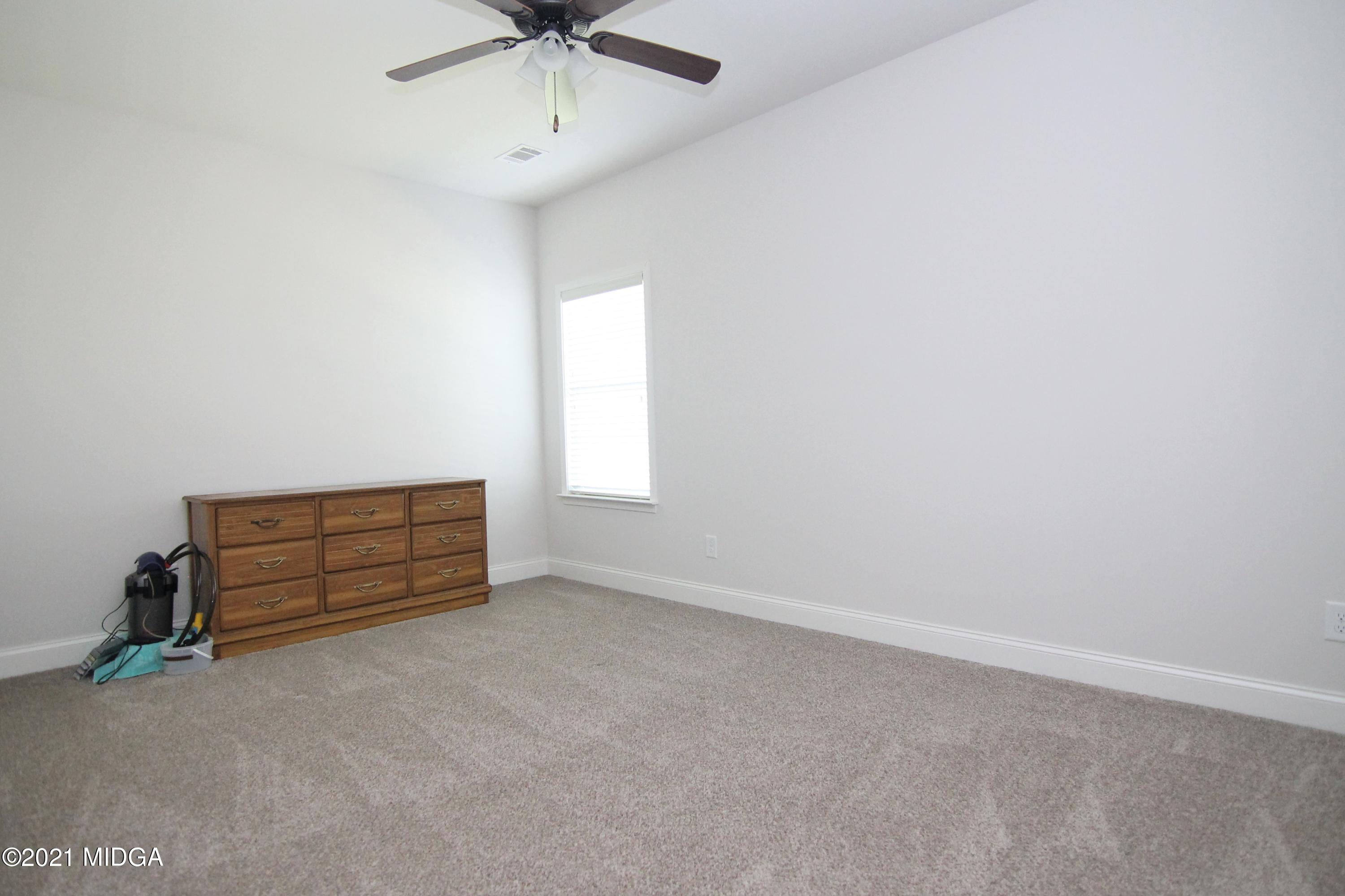 105 Timber Ridge Circle Byron, GA 31008 - Photo 22 of 28 an empty room with a ceiling fan and a window