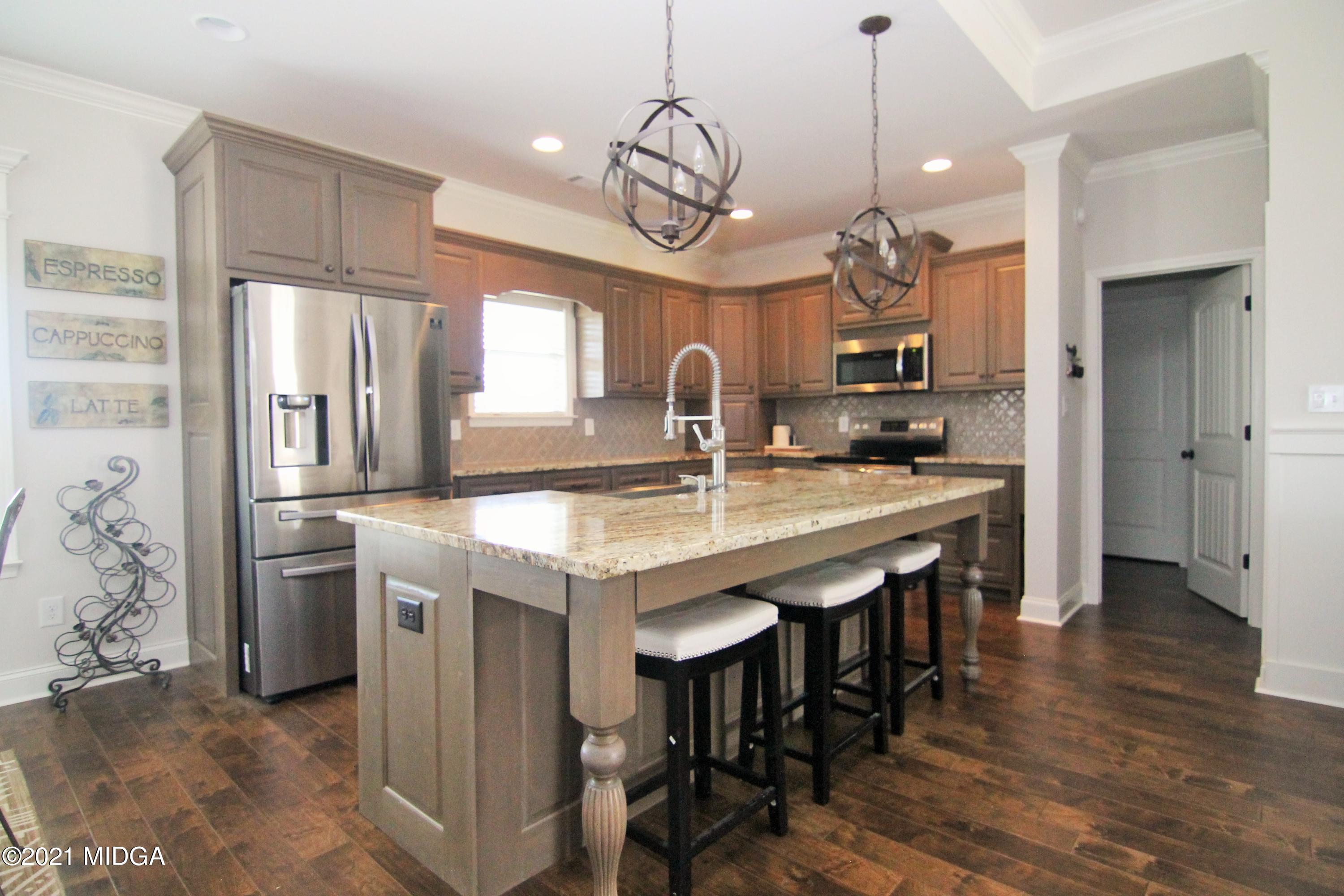 105 Timber Ridge Circle Byron, GA 31008 - Photo 7 of 28 a kitchen with stainless steel appliances granite countertop a kitchen island hardwood floor and a sink