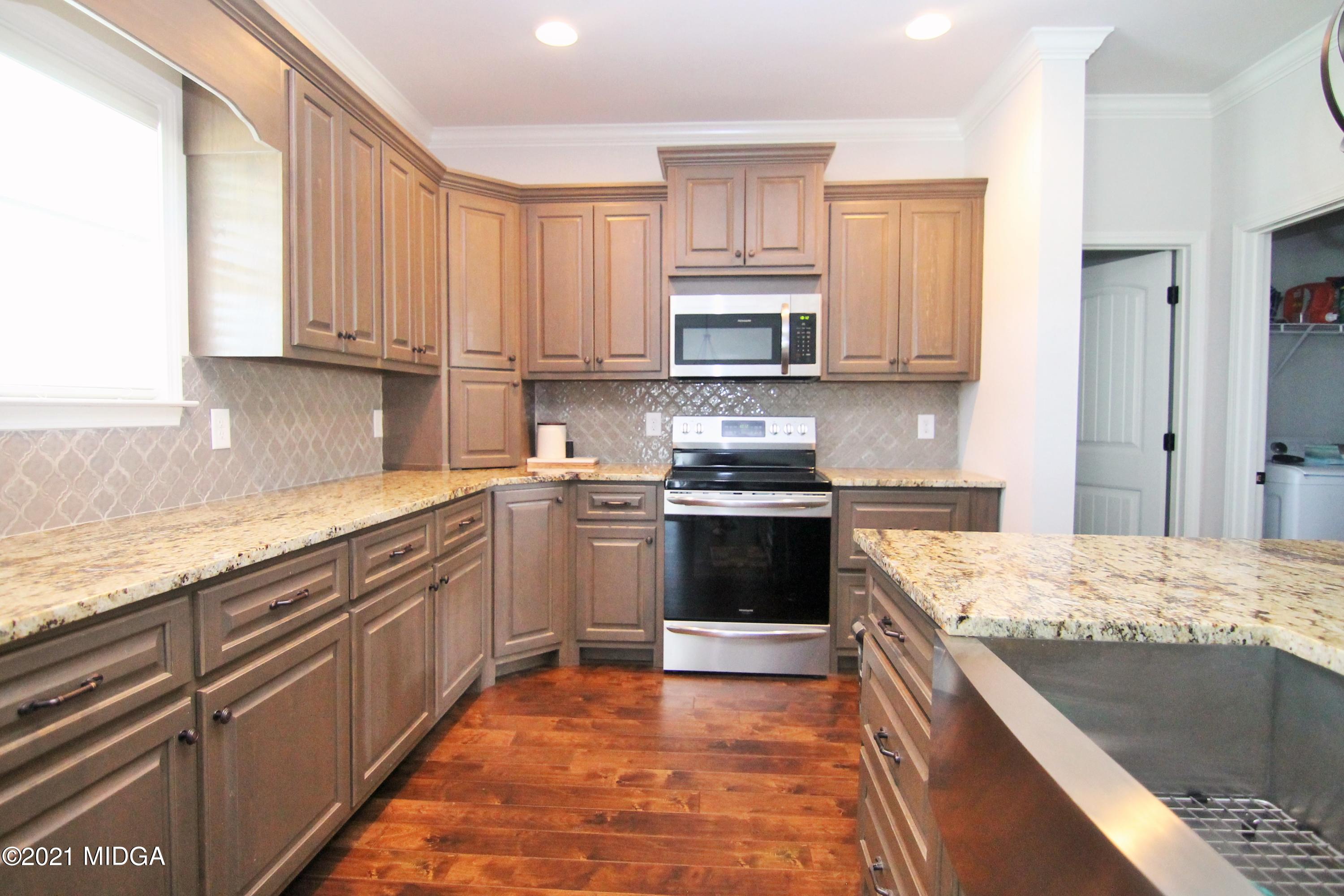 105 Timber Ridge Circle Byron, GA 31008 - Photo 9 of 28 a kitchen with stainless steel appliances granite countertop a stove sink and cabinets