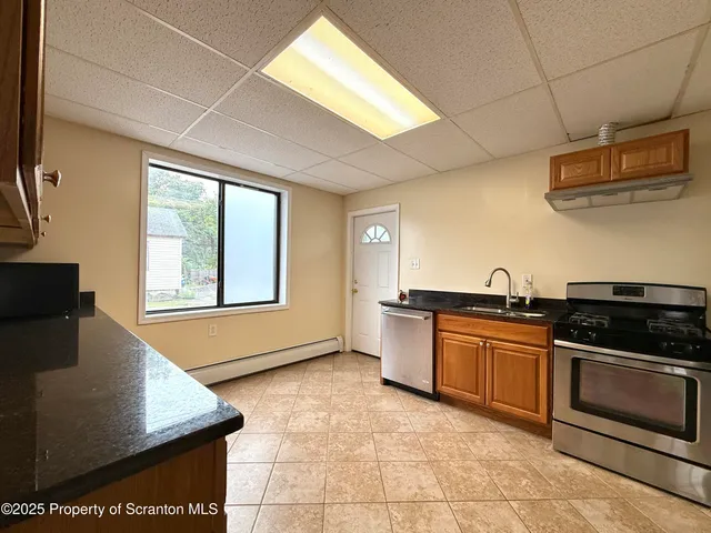 a kitchen with stainless steel appliances granite countertop a stove a sink and a microwave