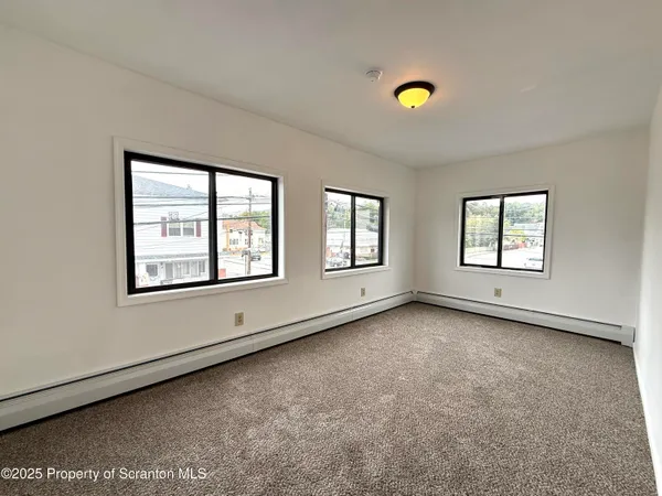 a view of an empty room with a window and a ceiling fan