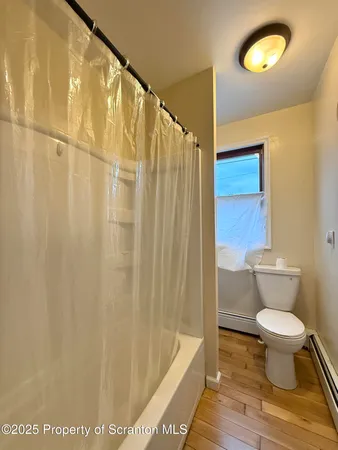 a bathroom with a toilet and a shower curtain