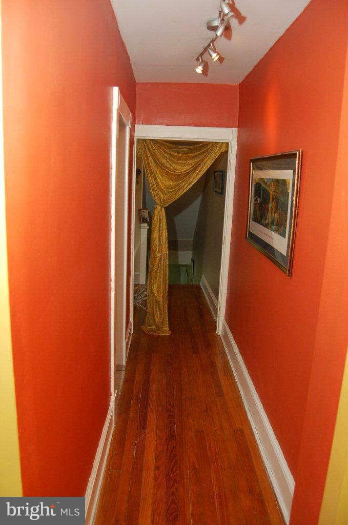 4616 Keswick Road Baltimore, MD 21210 - Photo 15 of 18 a hallway with wooden floor and a ceiling fan