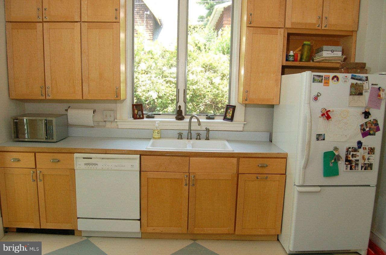 4616 Keswick Road Baltimore, MD 21210 - Photo 7 of 18 a kitchen with stainless steel appliances a sink a refrigerator and a cabinets