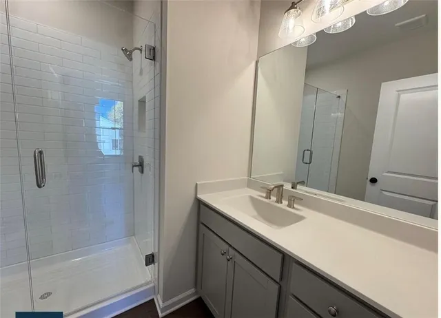 a bathroom with a sink a shower and a mirror