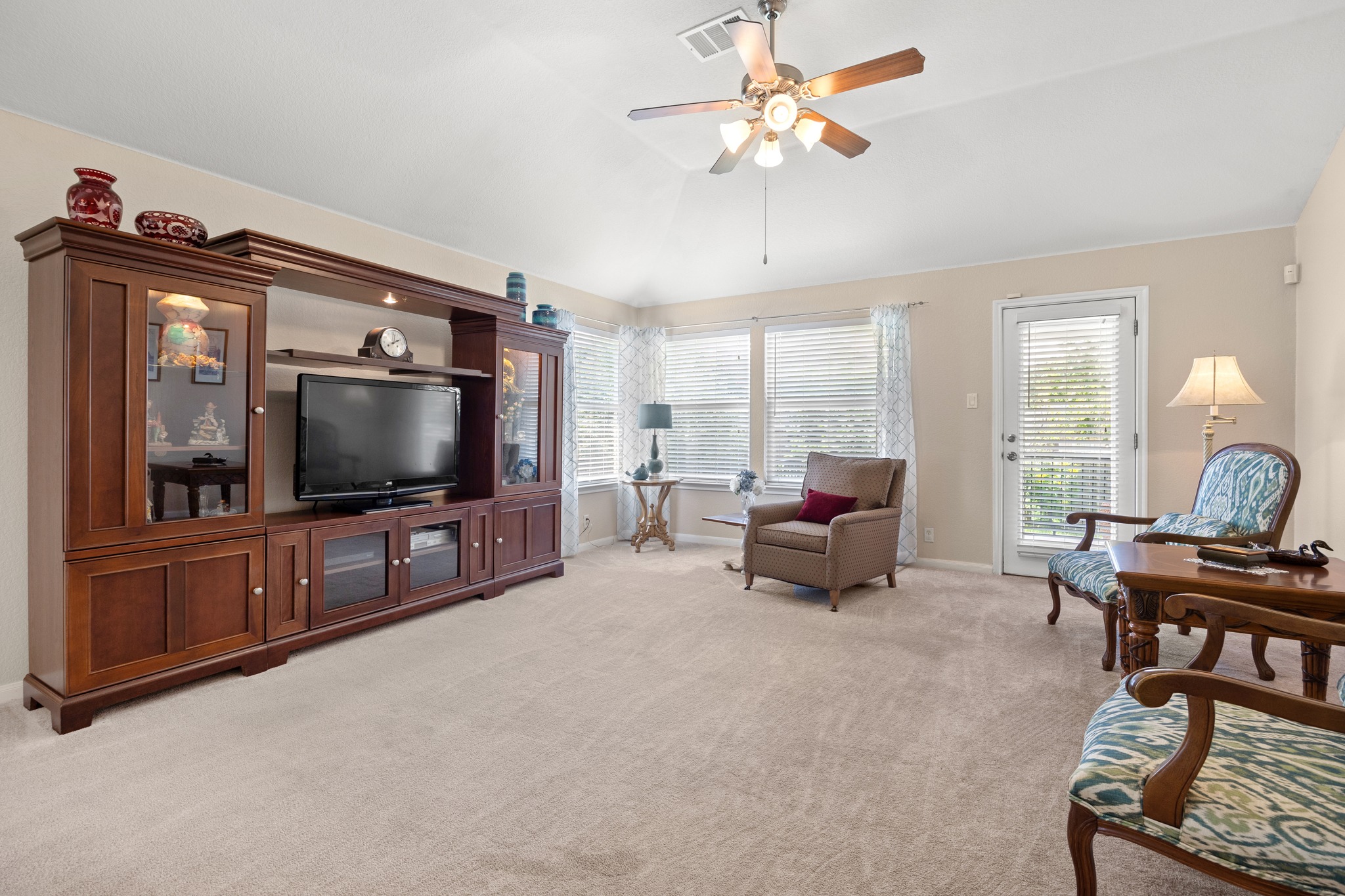 1108 Springbrook Road Pflugerville, TX 78660 - Photo 13 of 37 A comfortable living space boasts plush carpeting and abundant natural light from a wall of windows.