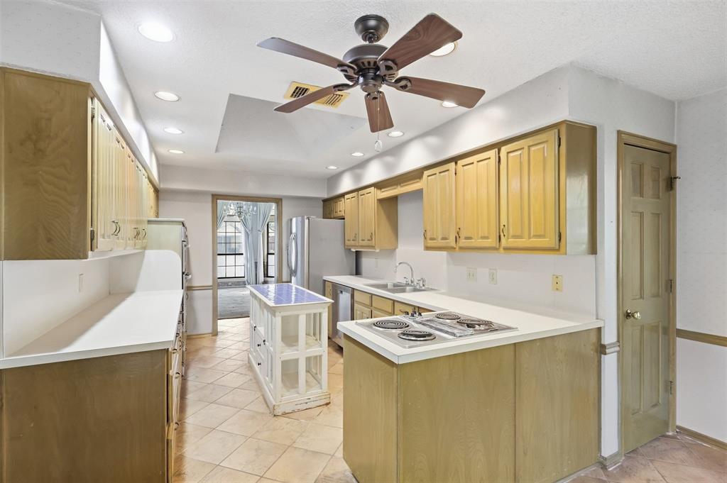 37 Timbergreen Circle Denton, TX 76205 - Photo 15 of 31 Recessed lighting, wood-finish cabinetry, tile flooring, ceiling fan, and white countertops