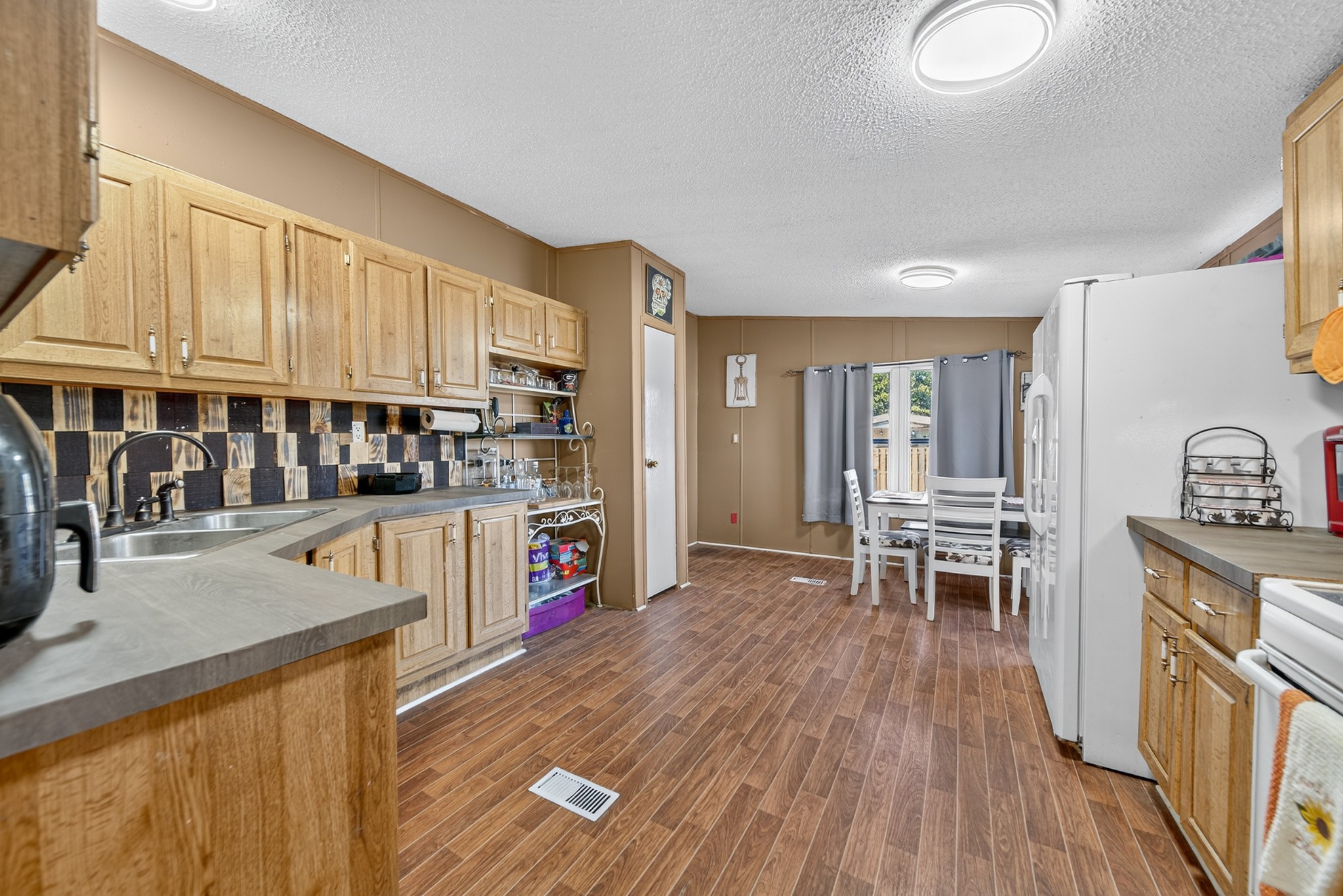 634 Pointe Lane Lafayette, TN 37083 - Photo 49 of 51 a kitchen with stainless steel appliances granite countertop a stove top oven a sink a dining table and chairs with wooden floor