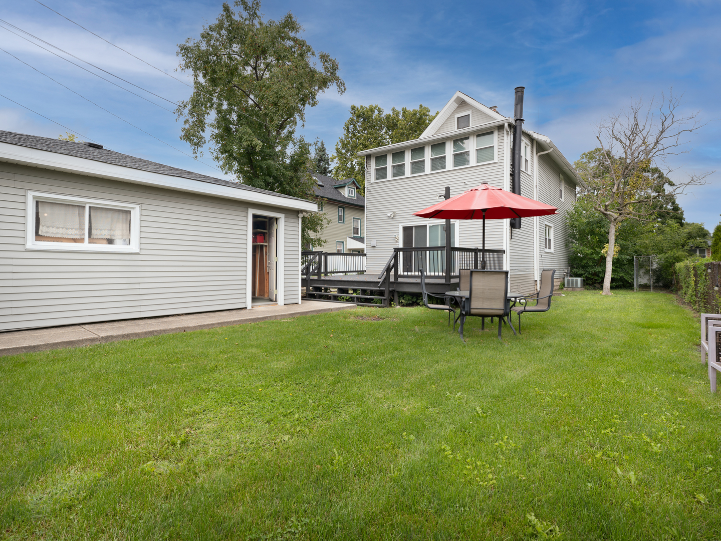 3439 West 66th Place Chicago, IL 60629 - Photo 26 of 31 a patio with a yard table and chairs under an umbrella