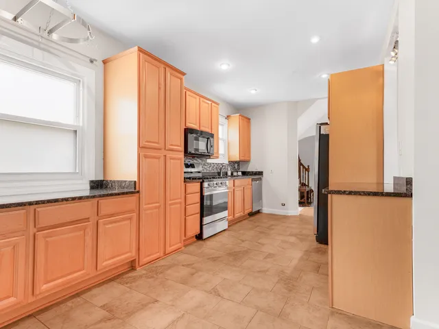 a kitchen with granite countertop a refrigerator and a sink
