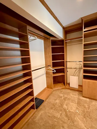 a view of walk in closet with empty racks