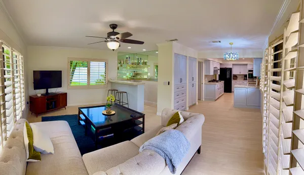 a living room with furniture a chandelier and a flat screen tv