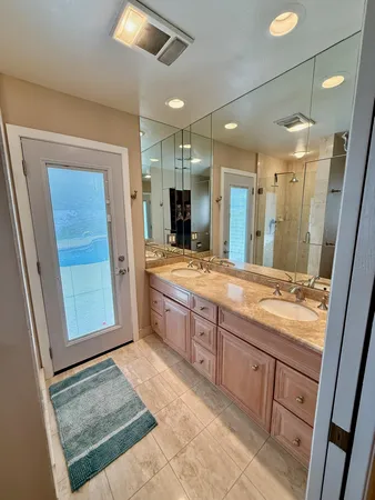 a bathroom with a granite countertop sink a mirror and a shower