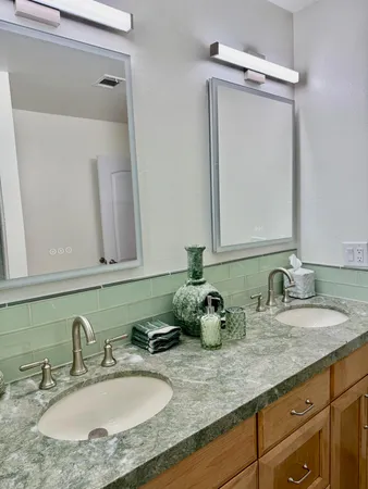 a bathroom with double vanity sinks and a mirror