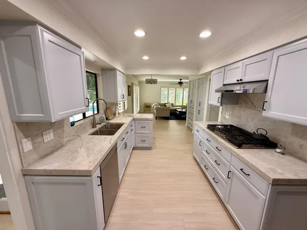 a kitchen with stainless steel appliances granite countertop a sink stove and refrigerator