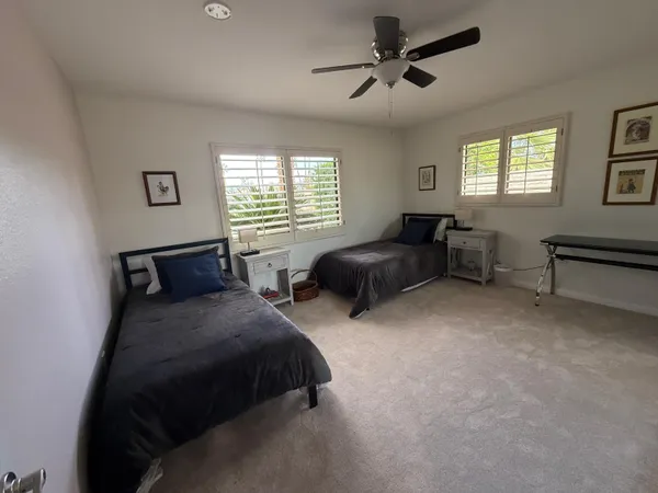 a bed room with two bed and a window