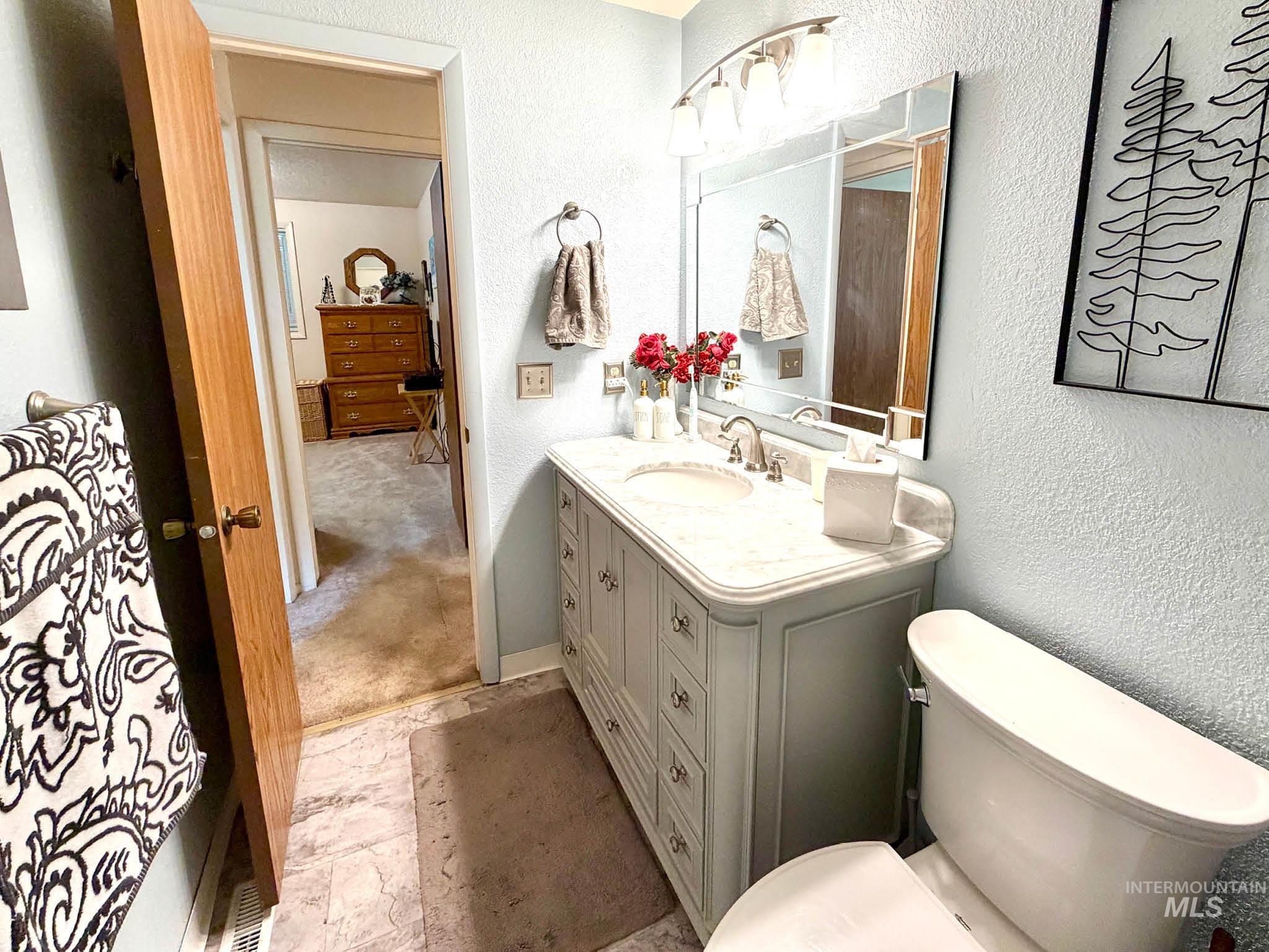3920 North Maple Grove Road Boise, ID 83704 - Photo 21 of 29 Bathroom featuring a single vanity with a curved countertop, an integrated sink, and brushed nickel hardware