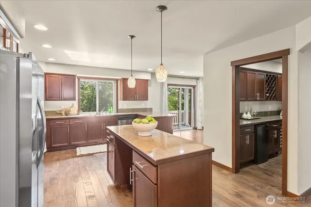 a kitchen with a stove a refrigerator a sink a oven and wooden floor