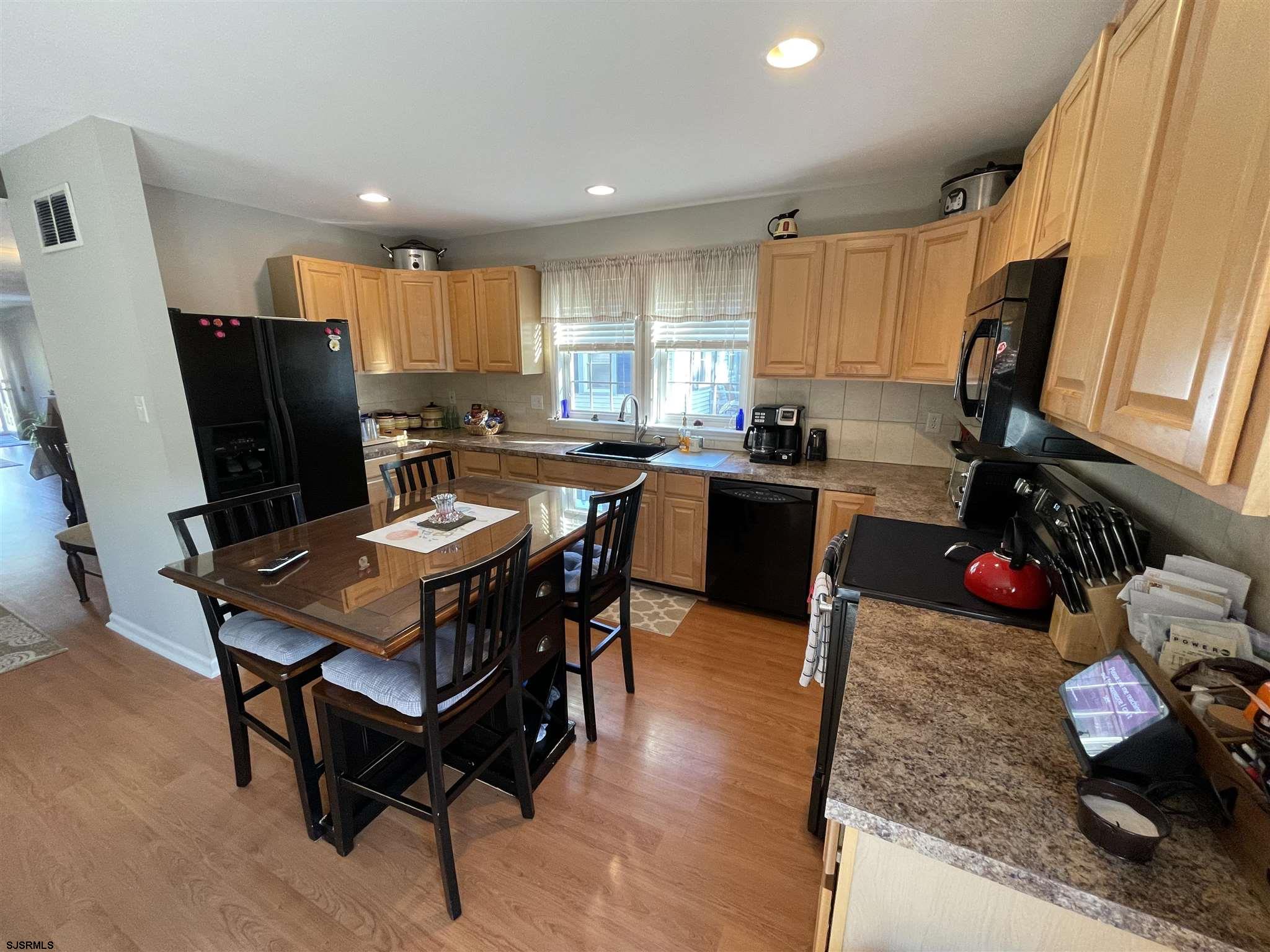 333 Shore Road Somers Point, NJ 08244 - Photo 6 of 25 a kitchen with a table chairs and a refrigerator