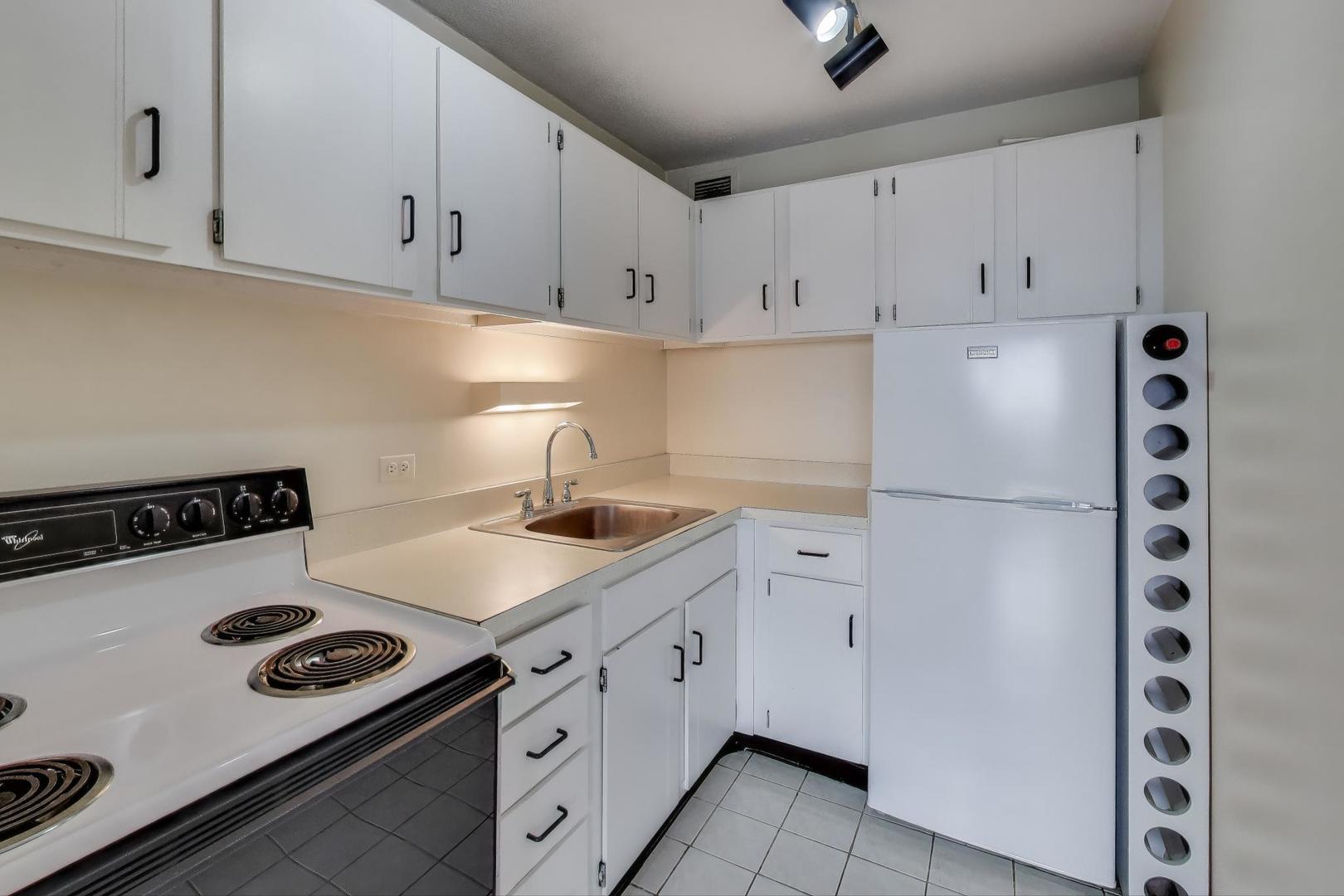 2728 North Hampden Court, Unit 1310 Chicago, IL 60614 - Photo 6 of 15 a kitchen with white cabinets and white appliances