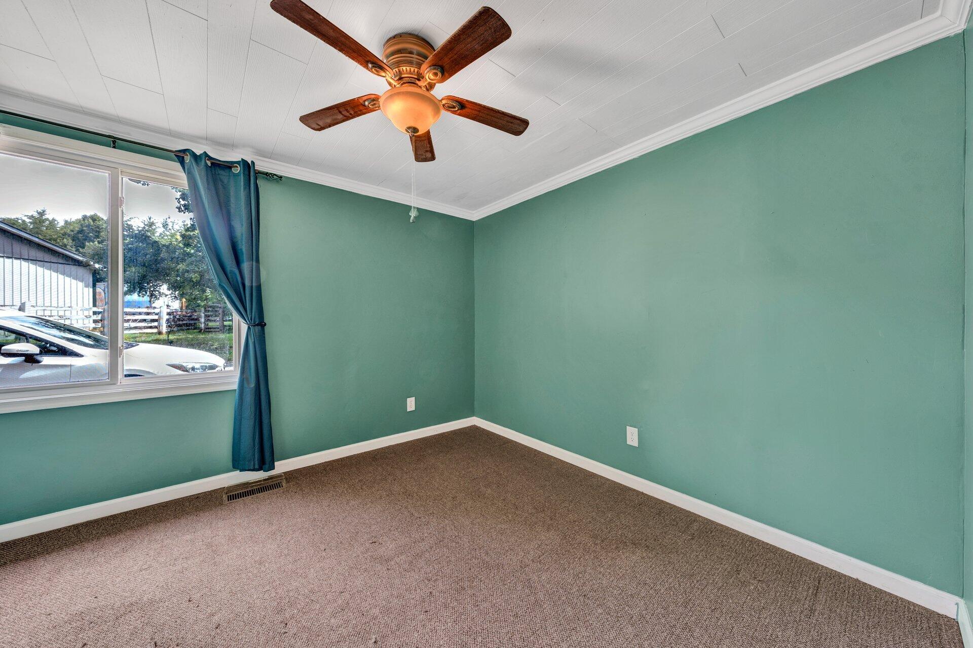 8342 Goodview Road Goodview, VA 24095 - Photo 14 of 30 an empty room with a window and a ceiling fan