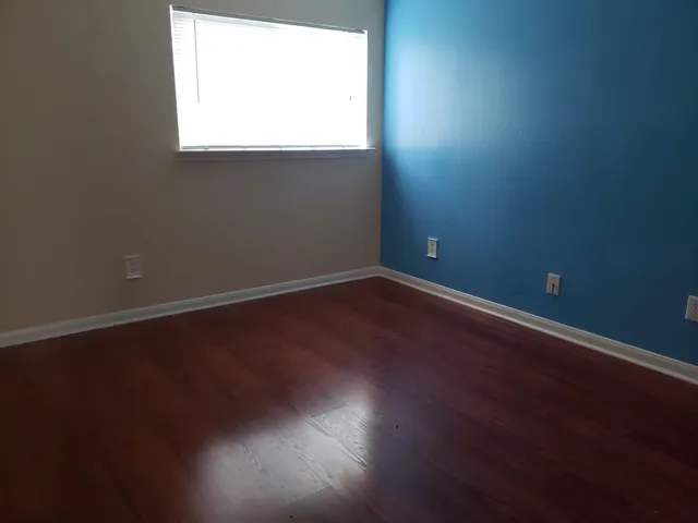 a view of a small space with wooden floor and a window