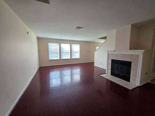 a view of a livingroom with wooden floor and a fireplace