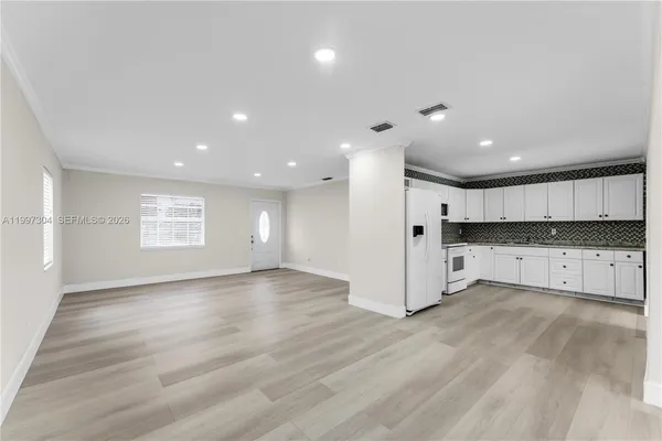 an empty room with wooden floor and window